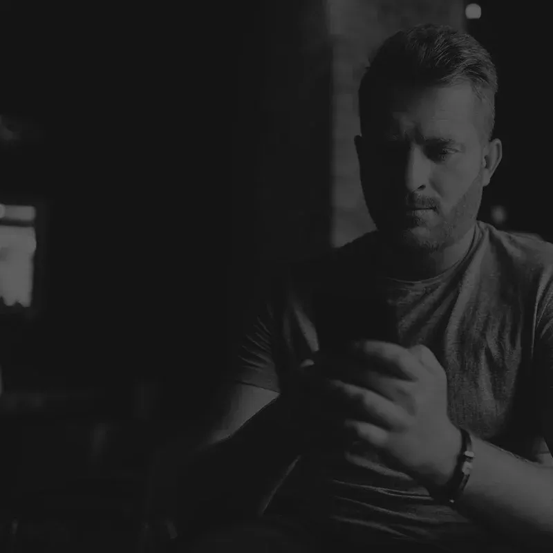 Adult man using phone indoors.